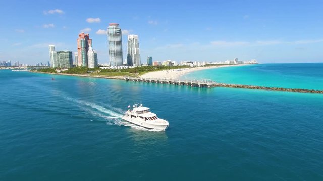 Aerial footage of boat leaving harbor and South Beach, Miami
