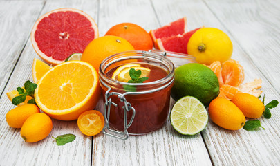 Jar of jam and fresh citrus fruits