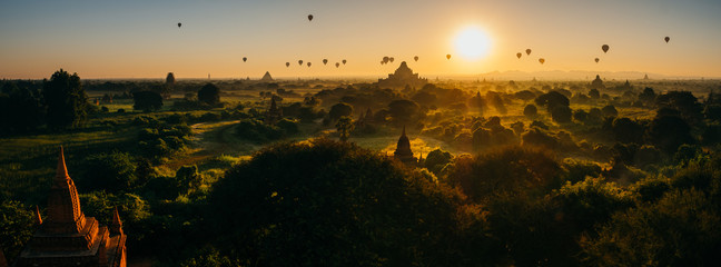Scenic sunrise with many hot air balloons above Bagan in Myanmar. Bagan is an ancient city with thousands of historic buddhist temples and stupas. panorama, bagan photo - obrazy, fototapety, plakaty