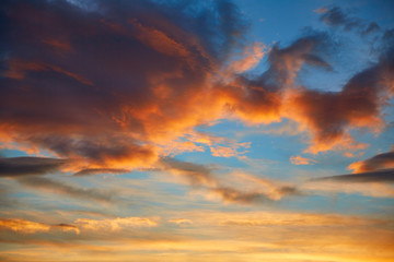Naklejka na ściany i meble Sunset sky orange clouds over blue