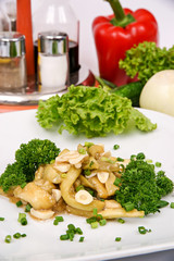 Salad of eggplant with garlic in a white plate, flavored with green onion and parsley