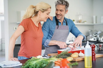 Couple d& 39 âge moyen s& 39 amusant à cuisiner ensemble dans la cuisine à domicile