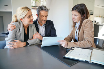 Real-estate agent reading terms of contract to clients