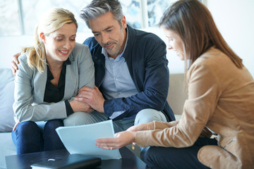 Real-estate agent reading terms of contract to clients
