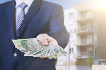 Polish businessman holds money. The loan on the house