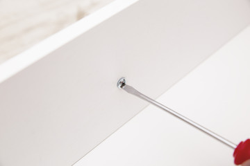 tightening the screw with a screwdriver
