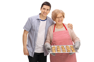 Young man and an old lady with tray of cookies