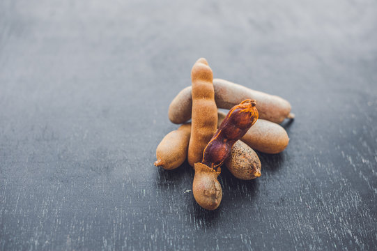 Sweet ripe tamarind pods on old wood background