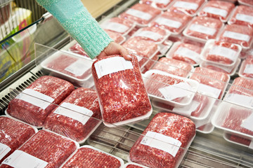Käuferfrau wählt gehacktes Fleisch im Laden