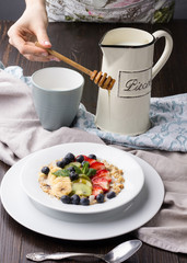 Breakfast on a brown table. Oatmeal with fruit.