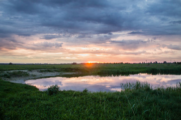 Fototapeta na wymiar sunset landscape over small rural lake