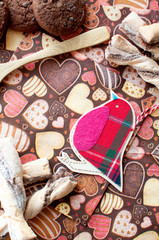 Red toy bird and cookies on dark napkin with image of hearts