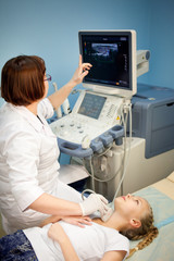 ultrasound device, the doctor makes examination of the thyroid gland in girls