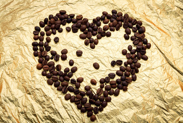 Heart from coffee beans on a gold foil background