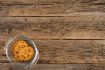 Peanut cookies in a glass bowl on old wooden table.