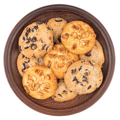 Cookies with peanuts and chocolate in a brown plate. Isolated on white background.