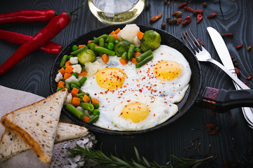 Delicious, tasty fried and mix vegetables on a pan. Top view of a wooden background. Close-up