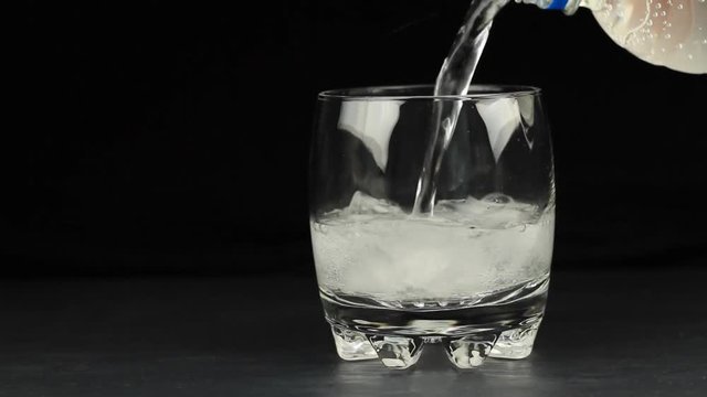 Pouring mineral water in the glass with ice cubes, lime and lemon slices 1920x1080p HD video