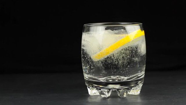 Mineral water in the glass with ice cubes,  lime and lemon slices