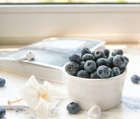 a Cup of fresh blueberry on a Sunny table