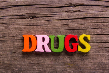 Fototapeta premium drugs word made from colored wooden letters on an old table. Concept