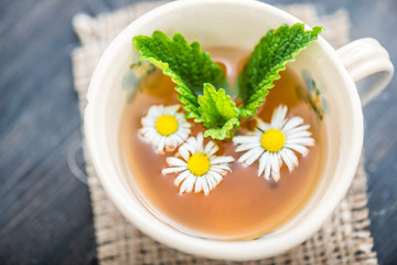chamomile tea in a glass cup on wooden background