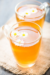 chamomile tea in a glass cup on wooden background
