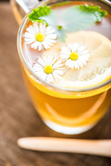 chamomile tea in a glass cup on wooden background