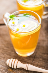 chamomile tea in a glass cup on wooden background