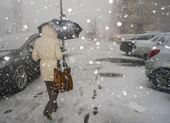 MOSCOW, RUSSIA - march 22, 2015:  .A woman under an umbrella walks down the street in the snow