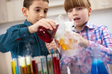 Obraz premium funny young scientist boy and girl working in laboratory