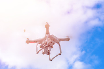 White drone, quadrocopter with photo camera flying concept on the sky.