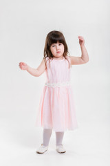 beautiful little girl in pink Princess dress on a gray backgroun
