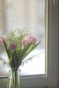 Букет тюльпанов в вазе на окне 