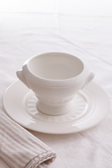 soup empty plate on a table with a white tablecloth and cloth. empty plate with place for soup. view from the side and from above