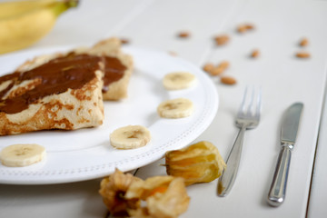 Pancakes with bananas and chocolate served on a plate