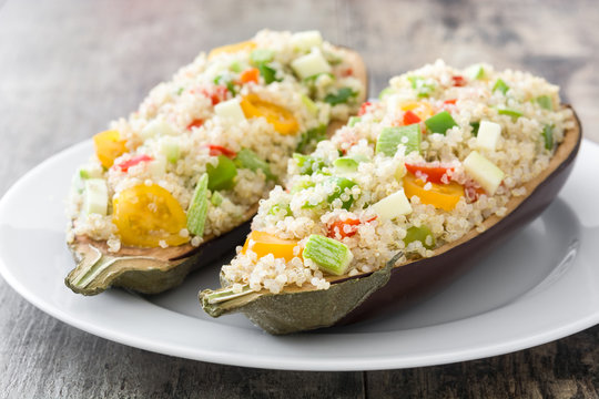 Stuffed eggplant with quinoa and vegetables on wooden background
