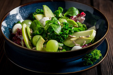 Fresh kale salad with avocado, lettuce and grape