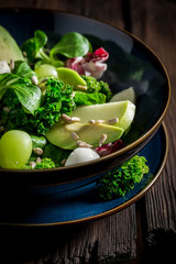 Healthy kale salad with mix of vegetables and avocado