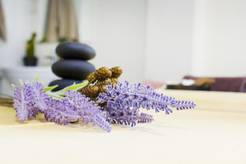 Obraz na płótnie Canvas Artificial lavender Flowers and zen basalt stones. background for spa