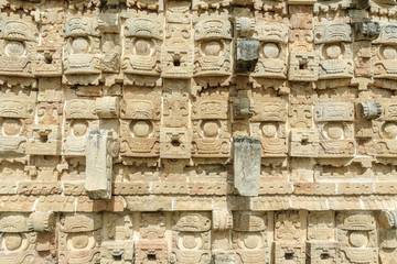 large masks of the Mayan god Chaac in the front of the palace of the masks or Codz Poop in the archaeological Kabah enclosure in Yucatan, Mexico.