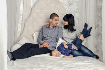 Family Relaxing Together In Bed