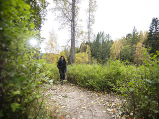 Fototapeta premium Young Female Hiker Walking On Forest Trail