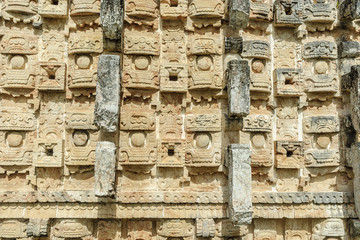 large masks of the Mayan god Chaac in the front of the palace of the masks or Codz Poop in the archaeological Kabah enclosure in Yucatan, Mexico.