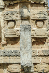 large masks of the Mayan god Chaac in the front of the palace of the masks or Codz Poop in the archaeological Kabah enclosure in Yucatan, Mexico.