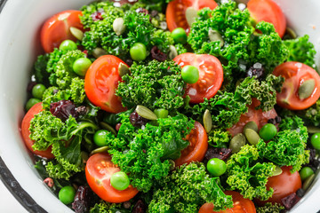 Diet kale salad with tomatoes, peas and cranberry