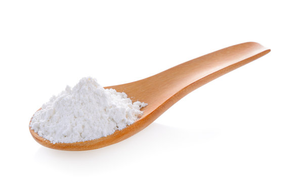 Pile of white wheat flour in wooden spoon