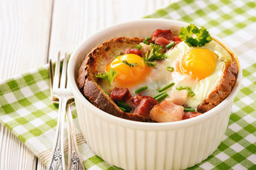 Eggs baked with bacon, tomatoes, garlic and bread.