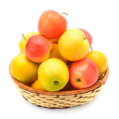 red and yellow apples in a wicker basket isolated on white background