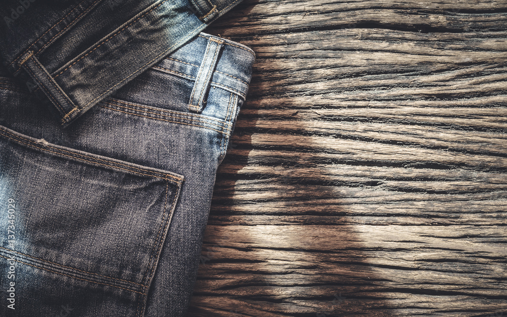 Wall mural Blue jeans on wooden background, Top view with copy space